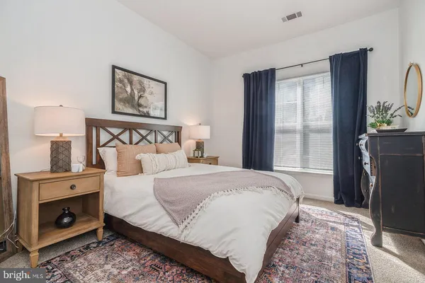 a bedroom with a bed a couch and a window