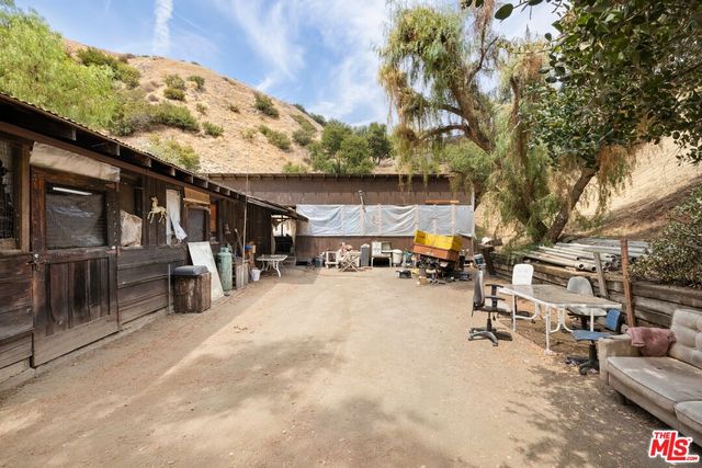 a view of a patio with couches table and chairs under an umbrella