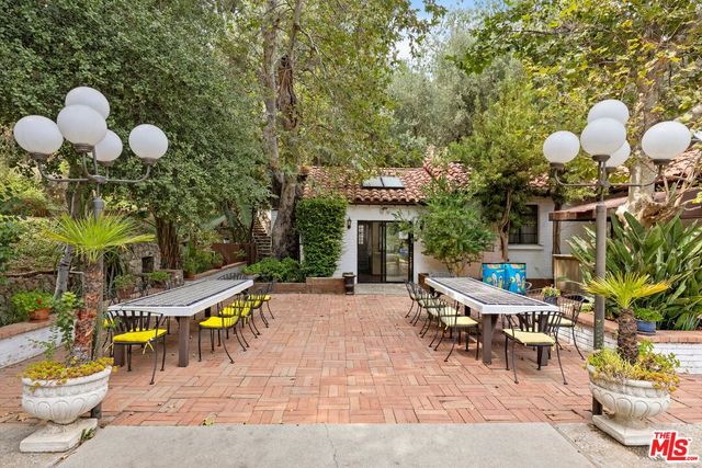 a view of a patio with table and chairs potted plants