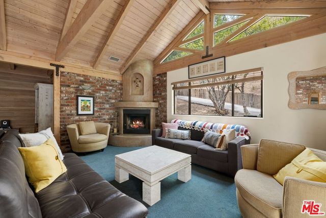 a living room with furniture a fireplace and a large window