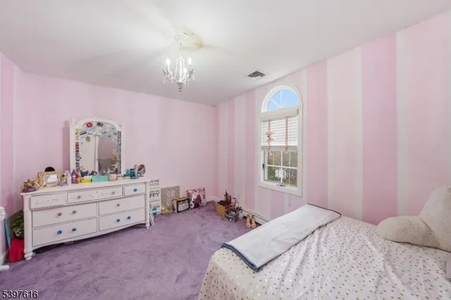 a bedroom with a bed and a mirror on dresser