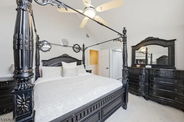 a bedroom with a bed and a mirror on the dresser