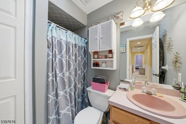 a bathroom with a sink vanity mirror and toilet