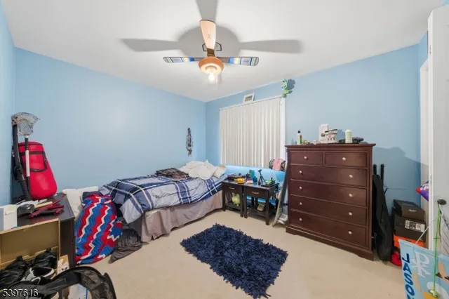 a bed room with a bed and a ceiling fan