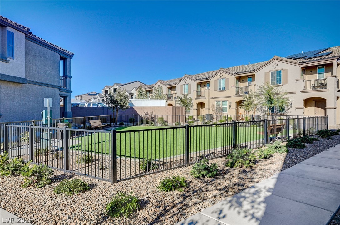 484 Filaree Place Henderson, NV 89015 - Photo 67 of 71 This residential complex features fenced green spaces, balconies, and solar panels for sustainable living.