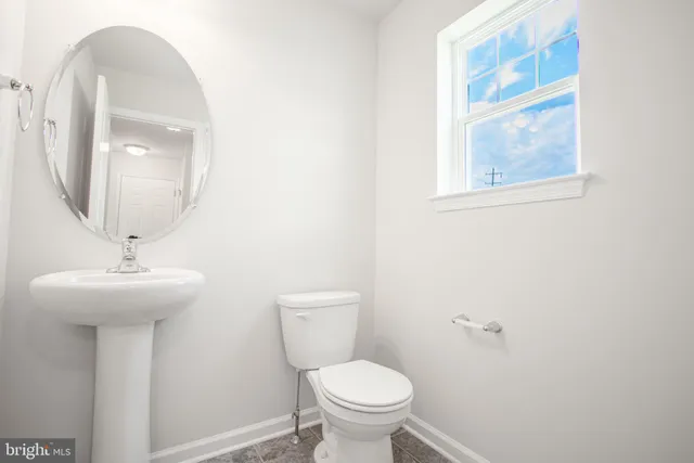 a bathroom with a toilet a sink and mirror