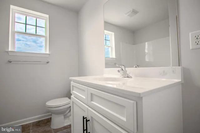 a bathroom with a sink vanity and a toilet