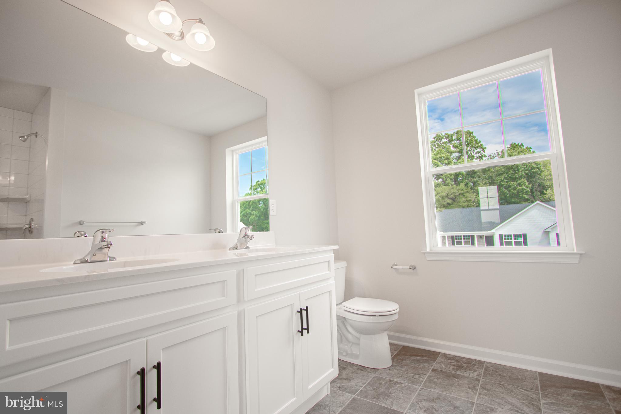 282 Valley View Circle, Unit 141 York, PA 17408 - Photo 38 of 43 a bathroom with a double vanity sink a toilet and a window