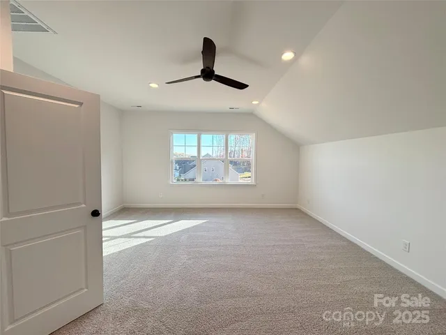 an empty room with windows and ceiling fan
