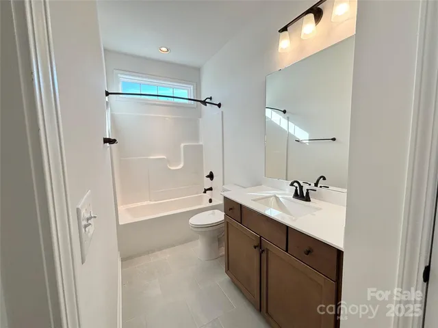 a bathroom with a double vanity sink toilet mirror and bathtub