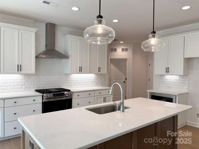a kitchen with a sink a stove and chairs
