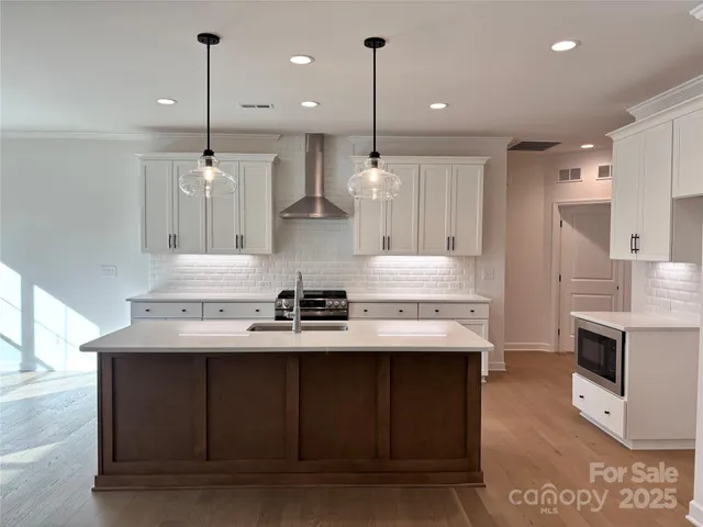 a kitchen with kitchen island a sink stainless steel appliances and cabinets