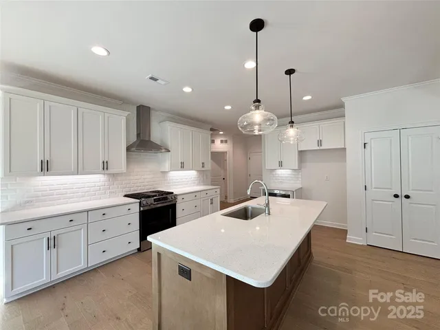 a large kitchen with kitchen island a sink stainless steel appliances and cabinets
