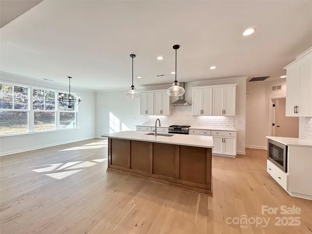 a large kitchen with kitchen island a sink stainless steel appliances and cabinets