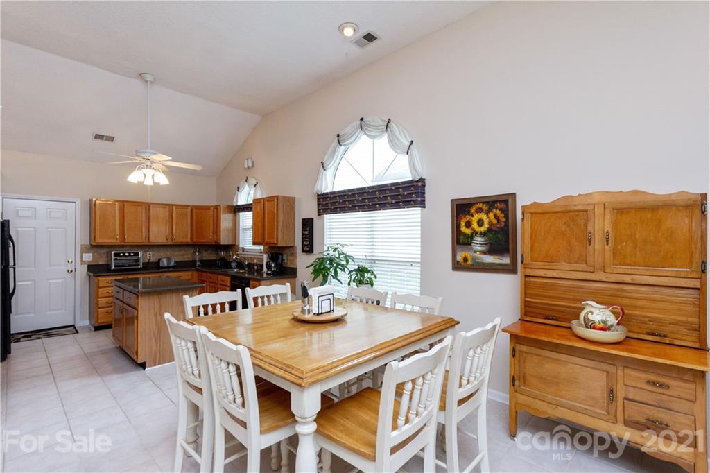7401 Reedy Creek Road, Unit 24 Charlotte, NC 28215 - Photo 11 of 31 a kitchen with stainless steel appliances granite countertop a sink a stove a dining table and chairs