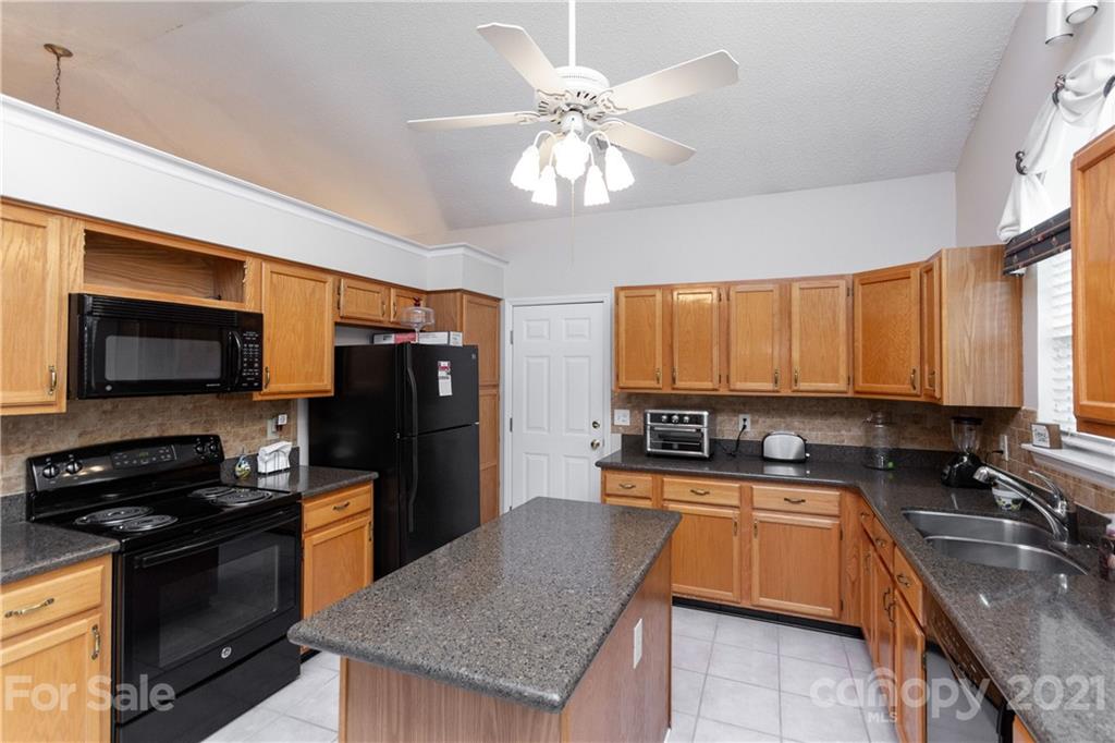 7401 Reedy Creek Road, Unit 24 Charlotte, NC 28215 - Photo 12 of 31 a kitchen with stainless steel appliances granite countertop a sink a stove cabinets counter space and a window