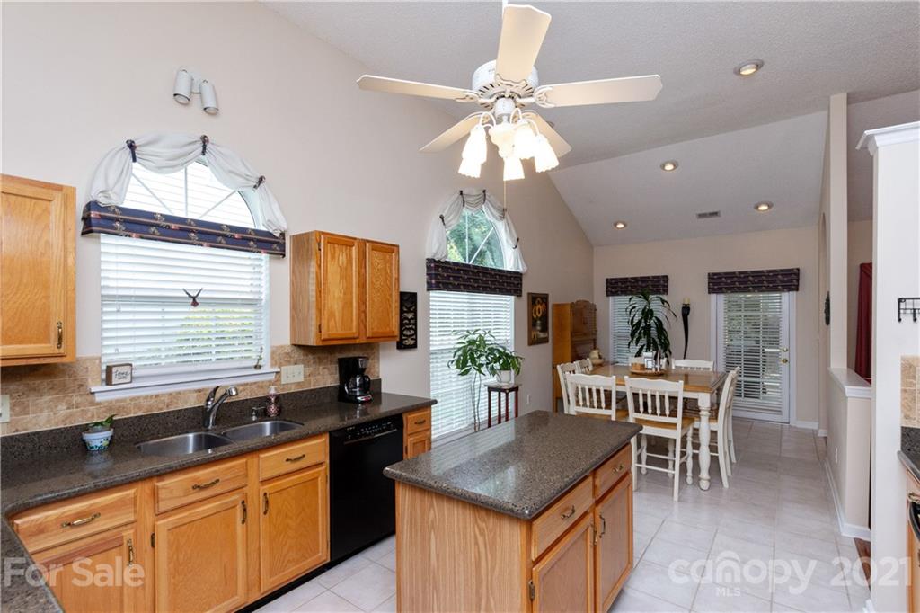 7401 Reedy Creek Road, Unit 24 Charlotte, NC 28215 - Photo 13 of 31 a kitchen with granite countertop a sink a counter top space and living room area