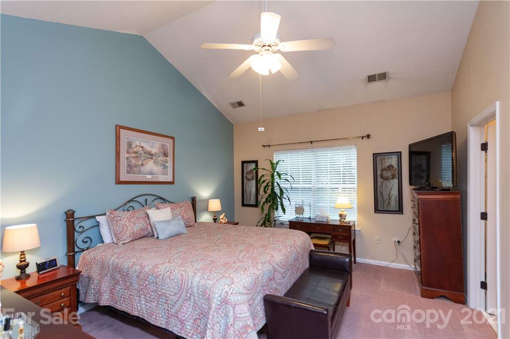 7401 Reedy Creek Road, Unit 24 Charlotte, NC 28215 - Photo 14 of 31 a bedroom with a large bed and a chandelier