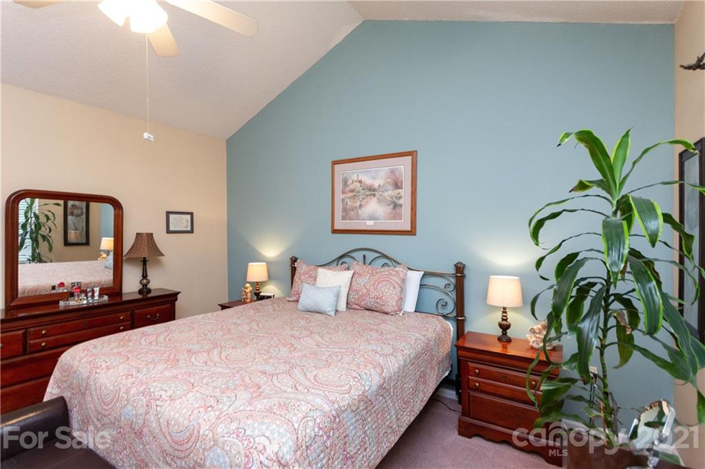 7401 Reedy Creek Road, Unit 24 Charlotte, NC 28215 - Photo 15 of 31 a bedroom with large bed and a potted plant