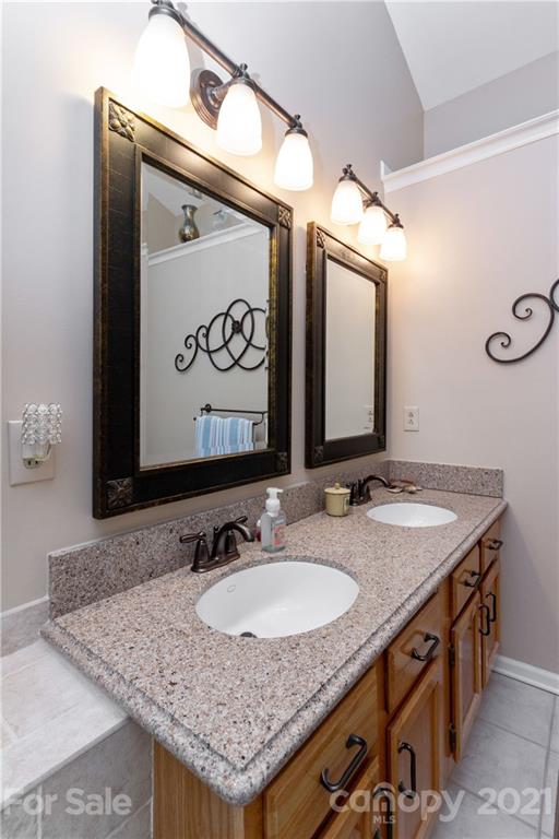 7401 Reedy Creek Road, Unit 24 Charlotte, NC 28215 - Photo 18 of 31 a bathroom with a granite countertop sink and a mirror
