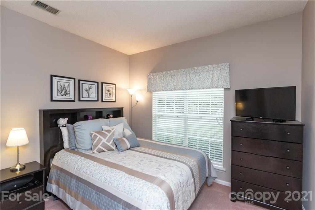 7401 Reedy Creek Road, Unit 24 Charlotte, NC 28215 - Photo 20 of 31 a bedroom with a bed and a flat screen tv