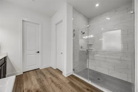 a bathroom with a glass shower door and a bathtub