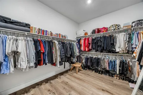 a view of walk in closet with clothes