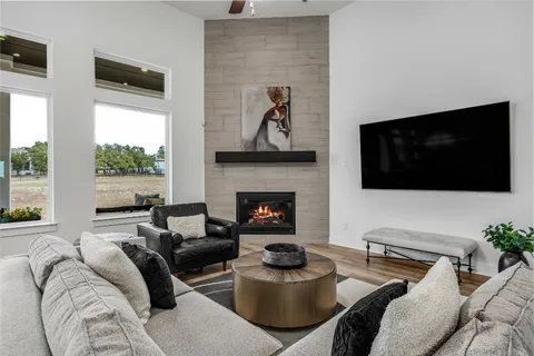a living room with furniture a flat screen tv and a fireplace