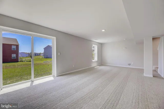 a view of an empty room with a fireplace and a window