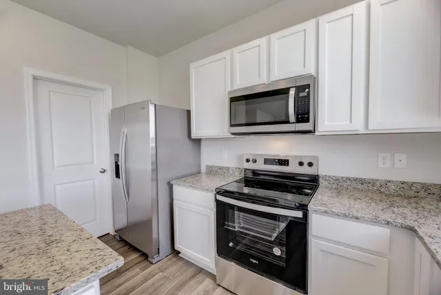 a kitchen with granite countertop cabinets and steel stainless steel appliances