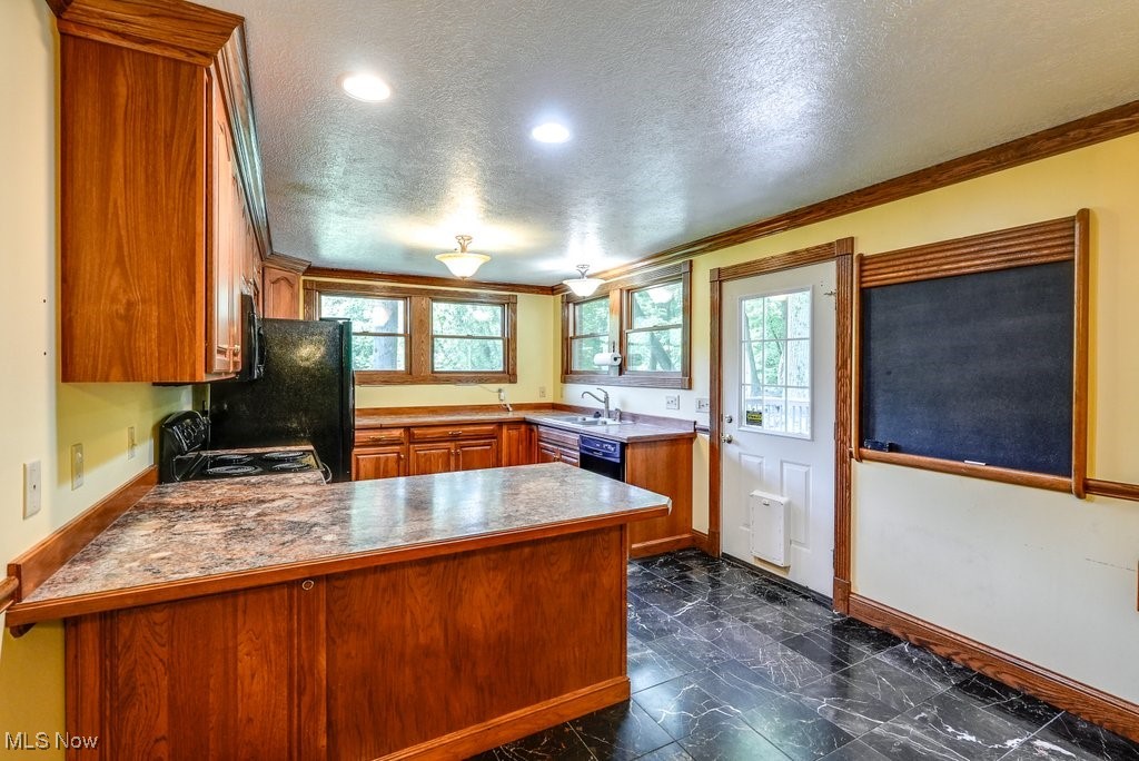12802 Clinton Road Doylestown, OH 44230 - Photo 26 of 49 Kitchen with kitchen peninsula, a textured ceiling, crown molding, and sink