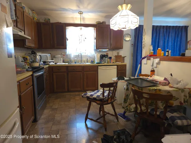 a kitchen with stainless steel appliances granite countertop a stove top oven a refrigerator a sink and dishwasher