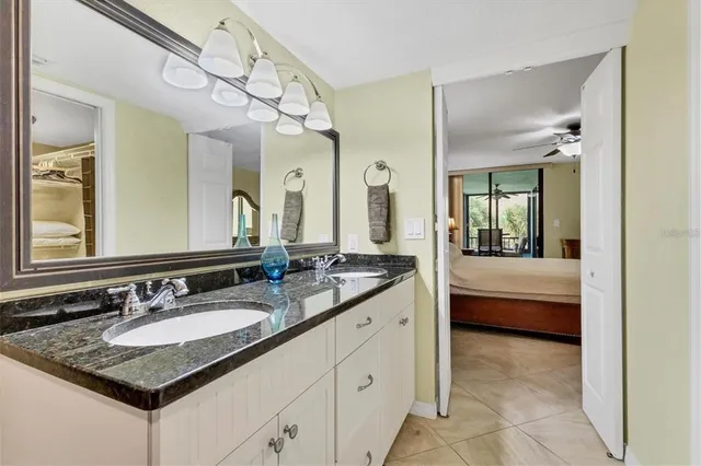 a en suite bathroom with a granite countertop sink a mirror and a bathtub
