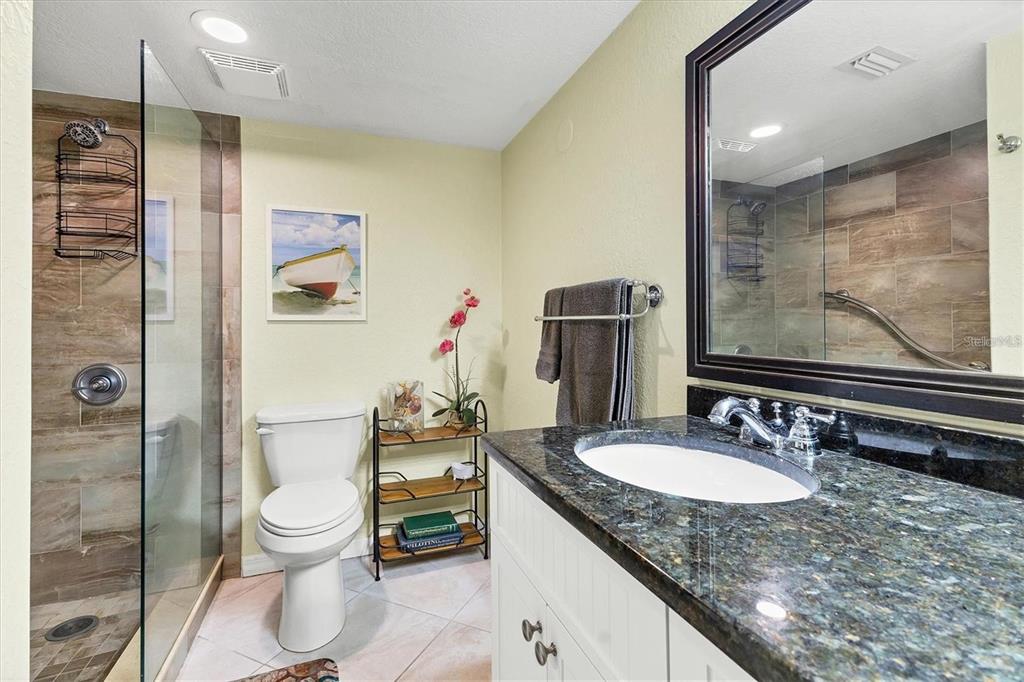 8776 Midnight Pass Road, Unit C307 Sarasota, FL 34242 - Photo 16 of 45 a bathroom with a granite countertop sink toilet and shower