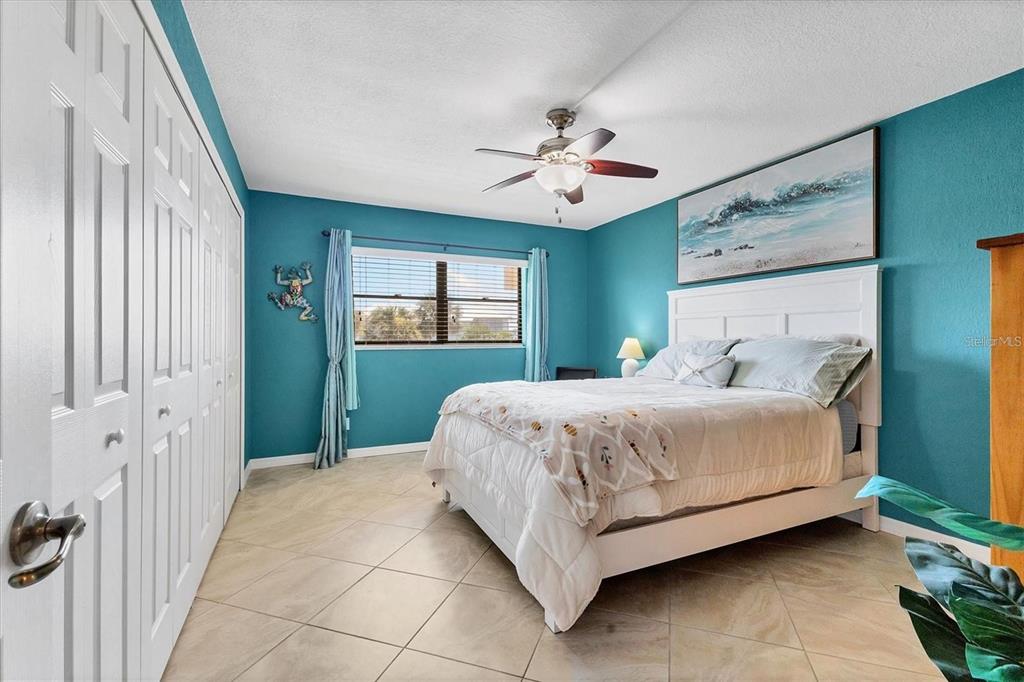 8776 Midnight Pass Road, Unit C307 Sarasota, FL 34242 - Photo 17 of 45 a bedroom with a large bed and a chandelier