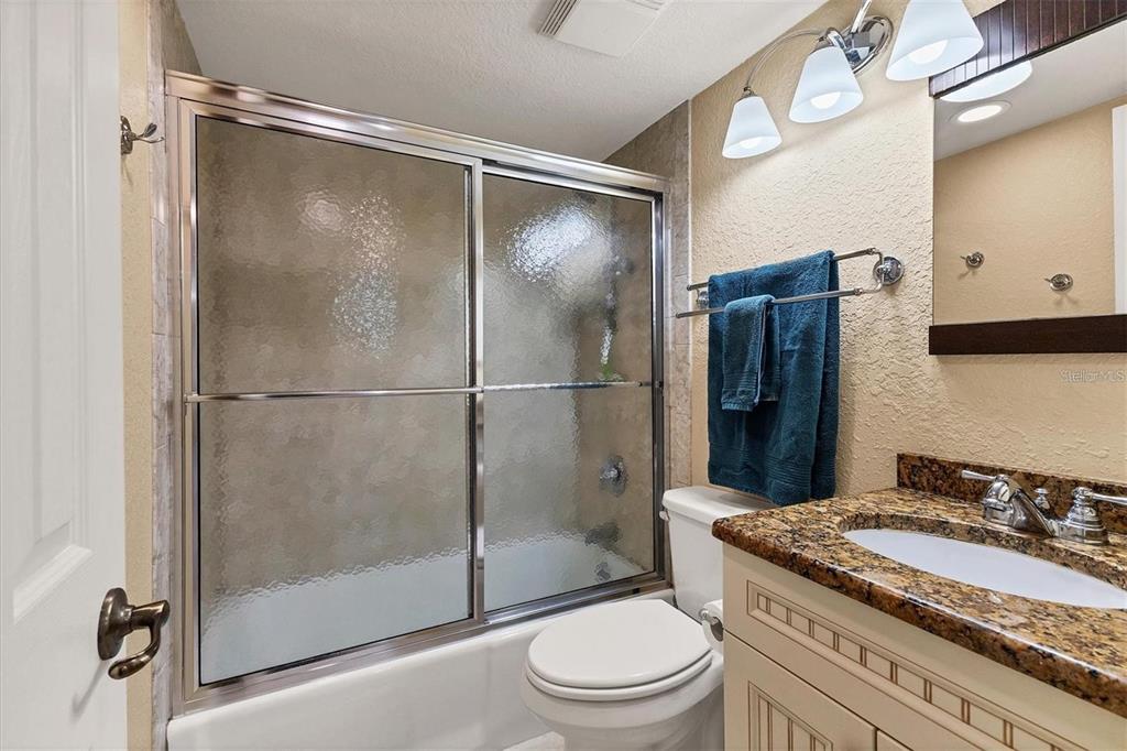 8776 Midnight Pass Road, Unit C307 Sarasota, FL 34242 - Photo 19 of 45 a bathroom with a granite countertop shower a toilet and a sink