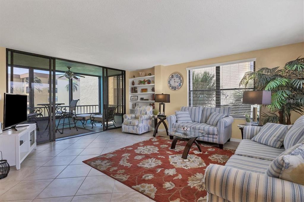 8776 Midnight Pass Road, Unit C307 Sarasota, FL 34242 - Photo 2 of 45 a living room with furniture and a flat screen tv