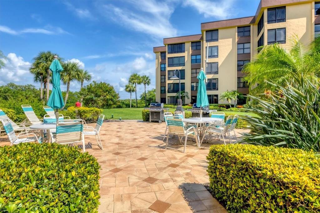8776 Midnight Pass Road, Unit C307 Sarasota, FL 34242 - Photo 30 of 45 a view of a building with garden and sitting area