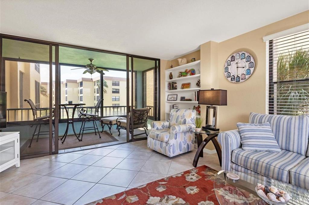 8776 Midnight Pass Road, Unit C307 Sarasota, FL 34242 - Photo 3 of 45 a living room with furniture and a floor to ceiling window