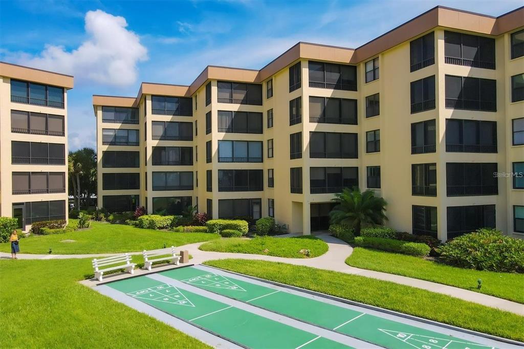 8776 Midnight Pass Road, Unit C307 Sarasota, FL 34242 - Photo 34 of 45 a view of a building with a yard