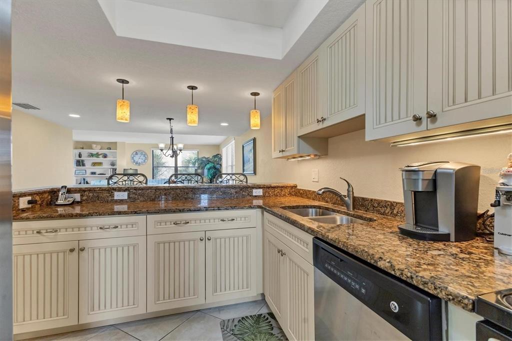 8776 Midnight Pass Road, Unit C307 Sarasota, FL 34242 - Photo 6 of 45 a kitchen with granite countertop a sink and cabinets
