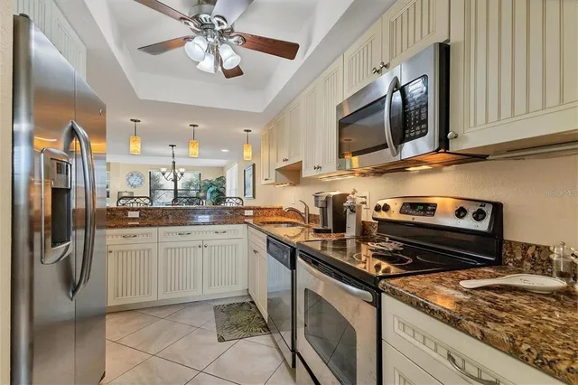 a kitchen with stainless steel appliances granite countertop a stove refrigerator and microwave