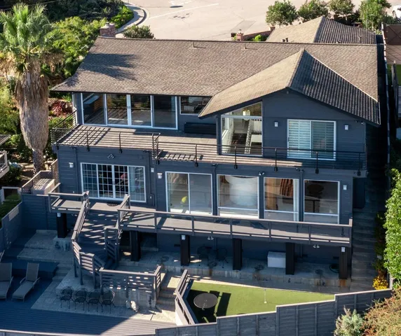 a view of a house with pool and chairs