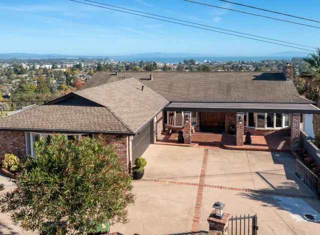 an outdoor view of house with swimming pool and ocean view