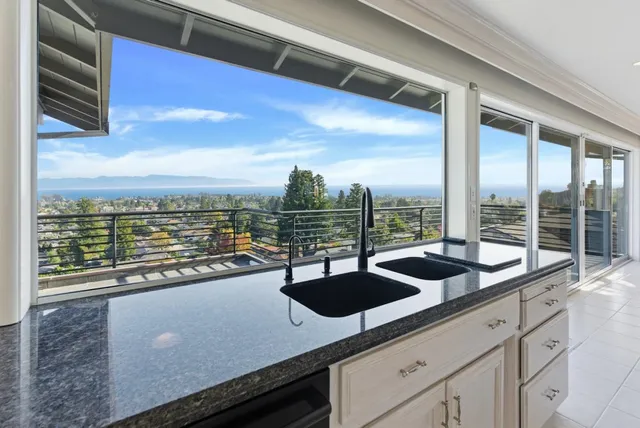 a spacious bedroom with a bed a dresser and a chandelier