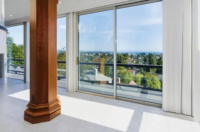 a living room with furniture a large window and wooden floor