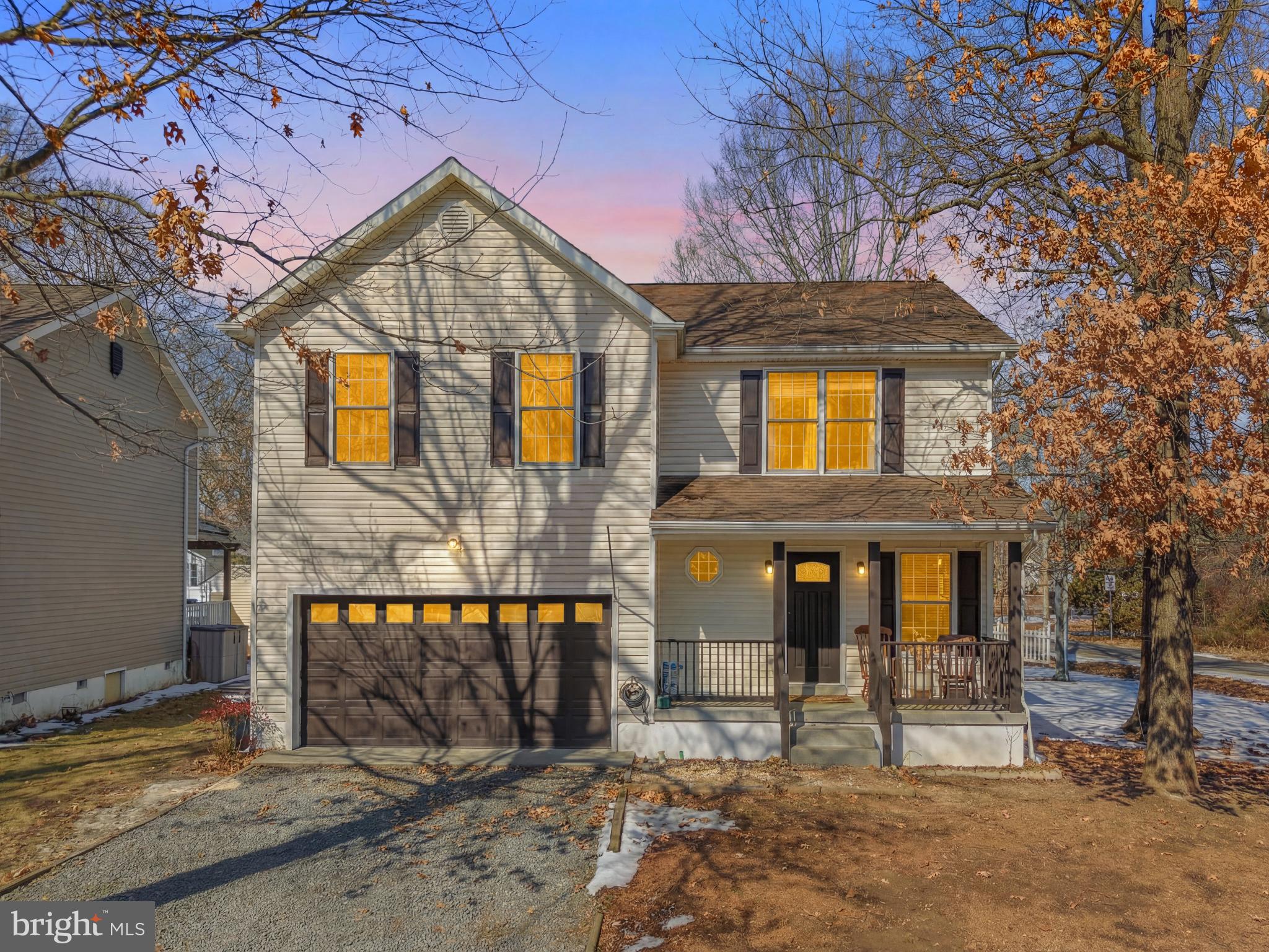 a front view of a house with a tree