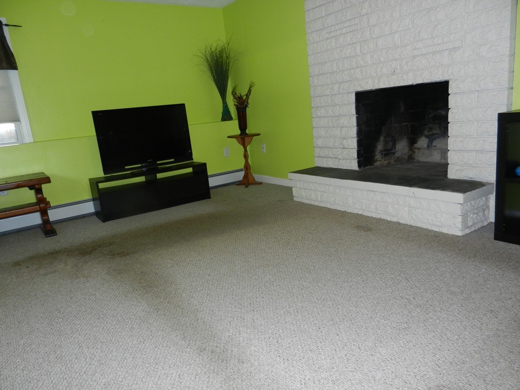 40 Indian Run Road Bellingham, MA 02019 - Photo 11 of 15 a living room with furniture flat screen tv and a fireplace