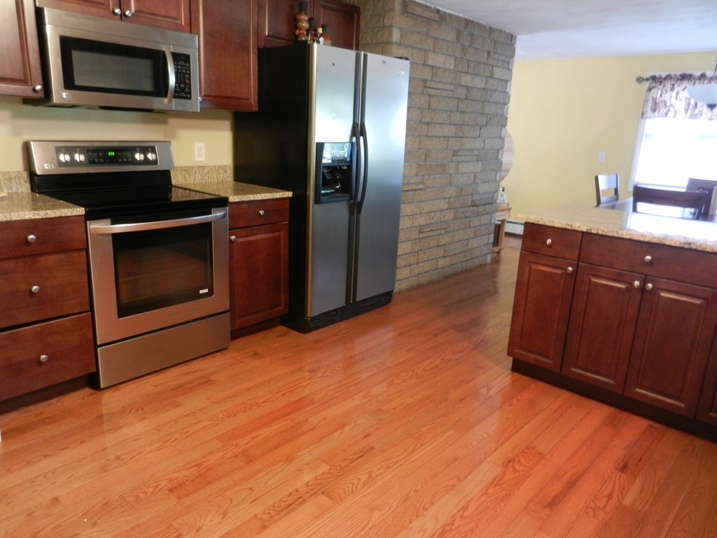 40 Indian Run Road Bellingham, MA 02019 - Photo 2 of 15 a kitchen with stainless steel appliances granite countertop a stove microwave and refrigerator
