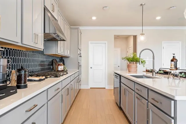 a kitchen with stainless steel appliances kitchen island granite countertop a sink and a refrigerator